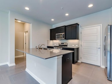 Kitchen with stainless steel appliances, an islan
