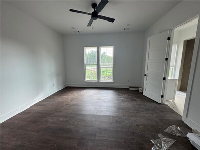 Unfurnished room featuring ceiling fan and dark w