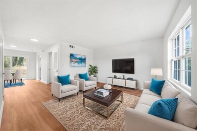 Living room with wood finished floors, baseboards, and recessed lighting