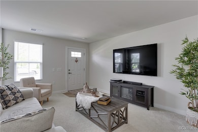 Living room with light carpet, baseboards, and vis