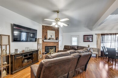 Living room with a brick fireplace, ceiling fan, a