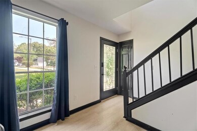 Entryway featuring stairway, light wood finished floors, and baseboards