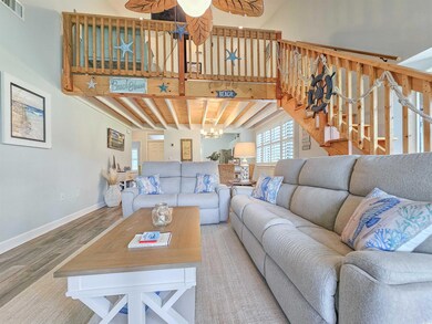 Living area with wood finished floors, baseboards, beam ceiling, and ceiling fan