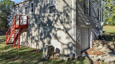 View of property exterior featuring an attached garage and a lawn