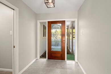 The photo shows a bright entryway with a decorativ