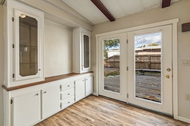 Entryway with wood finished floors and beam ceiling