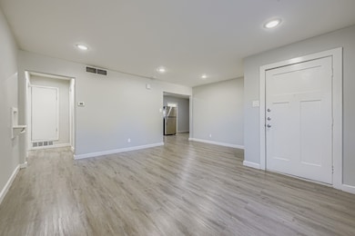 Empty room featuring light wood-style floors and recessed lighting
