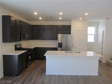 Kitchen featuring wood finished floors, a sink, ap