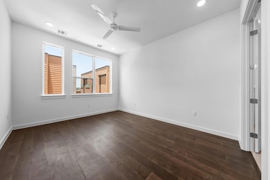 Empty room with a ceiling fan, dark wood-style fl
