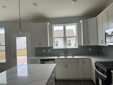 Kitchen featuring a sink, tasteful backsplash, app