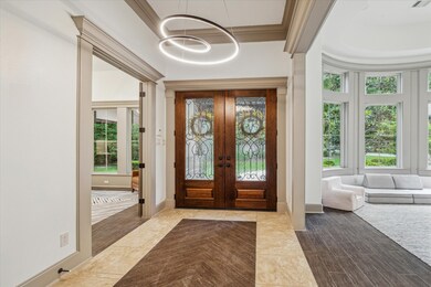 Foyer with high ceilings, double solid wood doors.