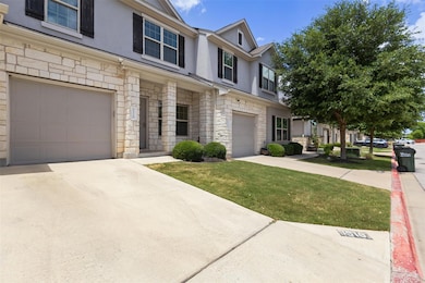 View of property featuring stone siding, an attac