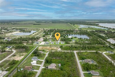 Aerial view of property's location featuring abundant farmland, a nearby body of water, and rural landscape