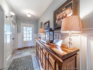 Large entryway with custom wainscoting and crown m