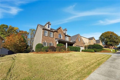 View of front of home featuring brick siding, a front yard, and a porch