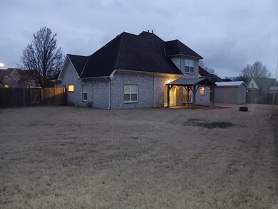 Rear view of property with a gazebo and a storage 