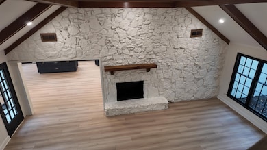 Unfurnished living room featuring light wood-style floors, a stone fireplace, and recessed lighting