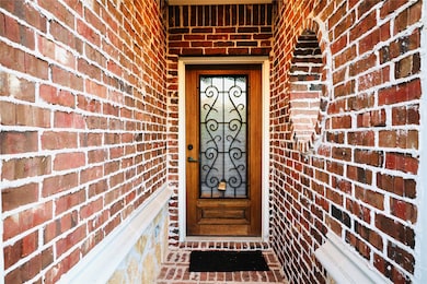 Entrance to property featuring brick siding