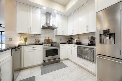 Fully renovated kitchen with quartz countertops, stainless steel appliances, custom cabinetry, and sleek lighting. Perfect for entertaining or quiet nights in.