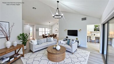 Living room featuring a chandelier, light wood finished floors, and high vaulted ceiling