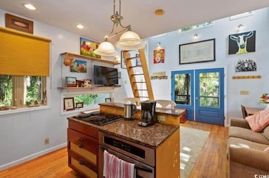 Kitchen featuring stainless steel oven, light wood