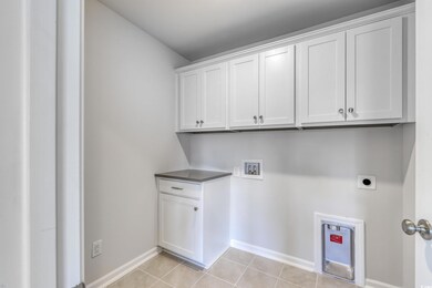 Washroom with light tile patterned floors, baseboa
