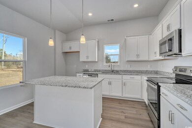 Kitchen with white cabinetry, a kitchen island, ap