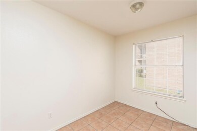Spare room featuring light tile patterned floors and baseboards