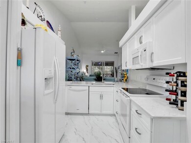 Kitchen with ceiling fan, sink, white cabinets, an