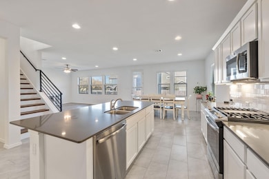 Kitchen with backsplash, a sink, stainless steel 