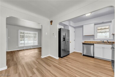 Kitchen featuring stainless steel appliances, white cabinetry, sink, and light hardwood / wood-style flooring