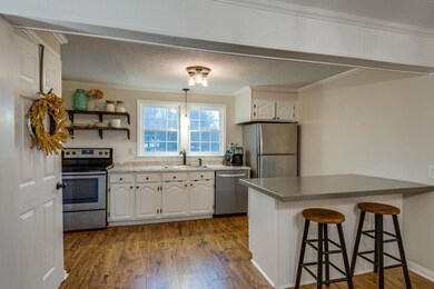 This kitchen offers stainless appliances, white cabinets, upgraded fixtures, new countertop, faucet, and large basin sink.