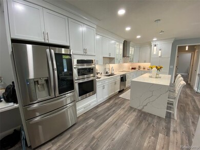 Kitchen with stainless steel appliances, a breakfast bar area, decorative backsplash, light stone counters, and dark wood finished floors