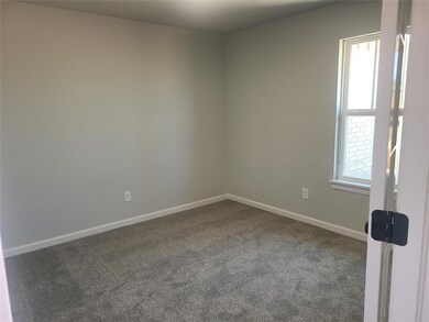 Spare room featuring dark colored carpet