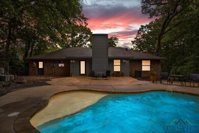 Pool at dusk with a patio, an outdoor pool, and fe