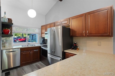 Kitchen featuring stainless steel appliances, tasteful backsplash, lofted ceiling, open shelves, and light stone counters