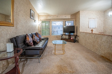 Living area featuring carpet and wallpapered walls