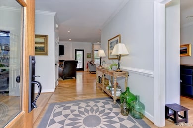Hallway with crown molding and light hardwood / wo