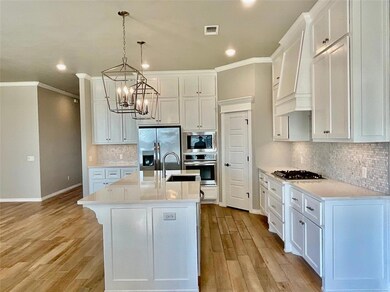 Kitchen with an island with sink, white cabinets, 