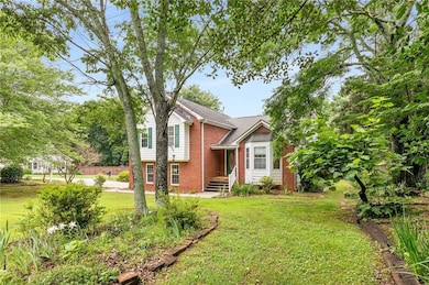 Split level home with a front lawn and brick siding