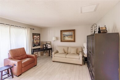 Living room with light hardwood / wood-style floors and a textured ceiling