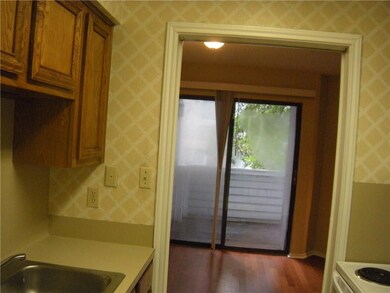 Kitchen featuring wallpapered walls, brown cabine