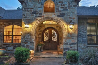 Darling covered porch that will welcome your guests. Heavy double doors with decorative windows and soaring high entry are featured. Finest quality and craftmanship and it shows when you enter through the charming double doors!