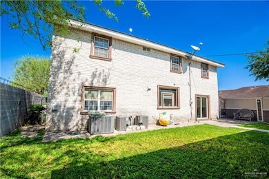 Rear view of house with brick siding, a fenced backyard, and a patio area