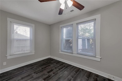 Spare room with ceiling fan and dark hardwood / wood-style floors