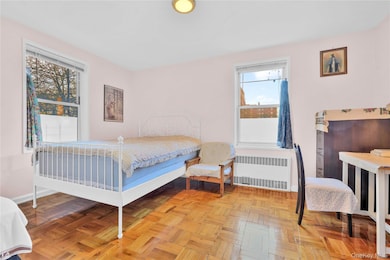 Bedroom featuring radiator heating unit and baseboards