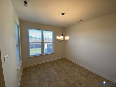 Empty room featuring a chandelier and stone finish floors
