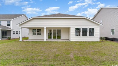 Rear view of house with a yard and a patio