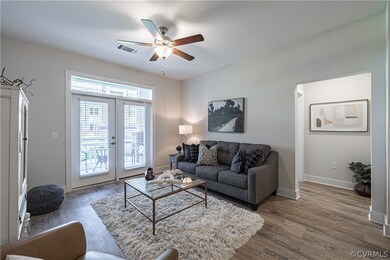 Living room with ceiling fan, french doors, and wo