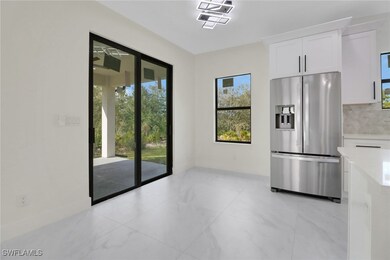 Kitchen with white cabinetry, stainless steel refr